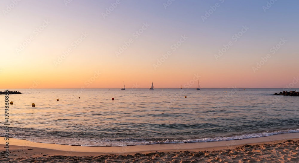 Naklejka premium Beautiful Sunset over Calm Ocean with Distant Sailboats and Sandy Beach.