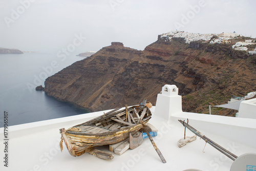 Old wooden boat and view of Fira (Thira) town on Santorini island, Greece