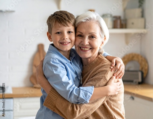 A young boy lovingly embraces his grandmother in a cozy kitchen