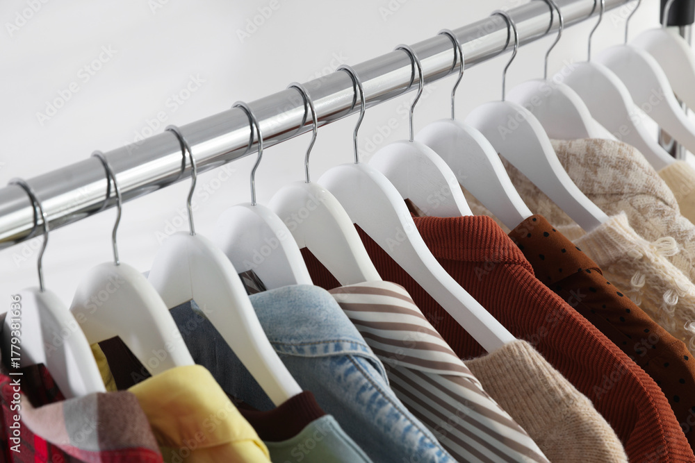 Fototapeta premium Different stylish clothes hanging on rack indoors, closeup