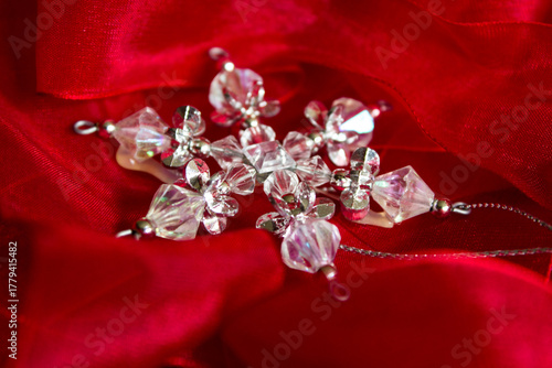 A Christmas tree decoration, made from crystal beads to look like a snowflake on a red material
