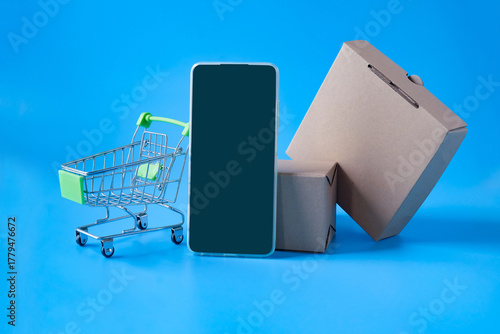 Smartphone with small shopping cart on color background,shopping online concept.