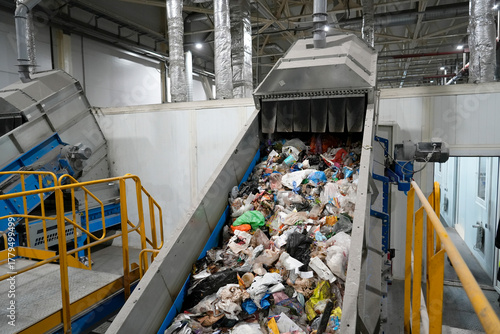 A conveyor belt with waste at a plant, waste moves along the belt to be sorted into fractions and collected for further processing.