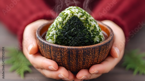 Steamy Onigiri Rice Ball Held in Hands with Nori and Greenery on Rustic Table