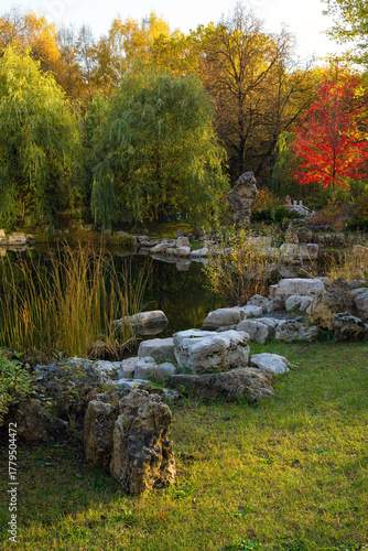 A pond in a city park at sunset in autumn.