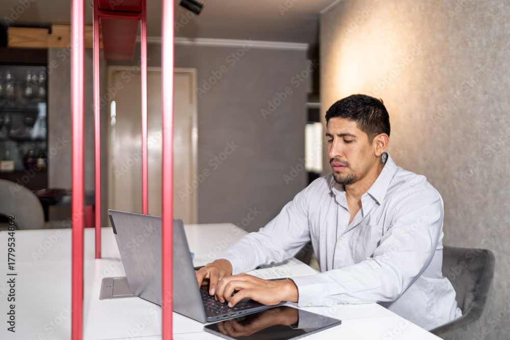 Fototapeta premium Man typing on laptop in modern office space