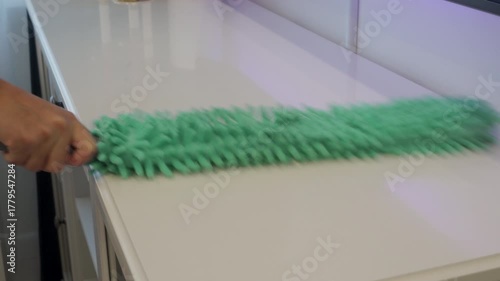 A Quick Whoosh to a Dust-Free Shine: Person Dusts Furniture at Home.