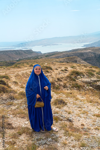 Dagestan, Sulak Canyon, turquoise water below in the mountains on a sunny day, a Muslim woman