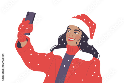 A woman in a Santa hat takes a selfie with her smartphone on a snowy day.