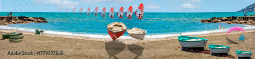 DREAM N°124 – Boats That Dream of Flying. Surreal and conceptual artwork depicting small boats floating above the beach as red sailboards glide across the turquoise sea.