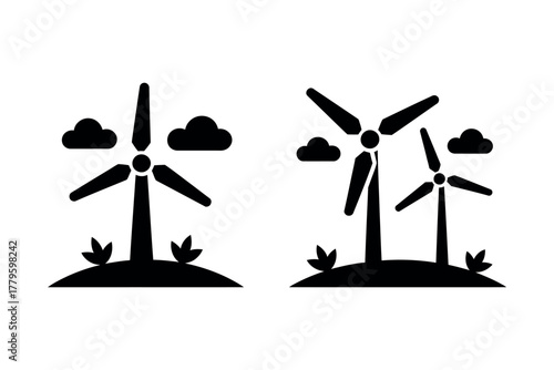 Two wind turbines stand tall under cloudy skies with grass at their bases.