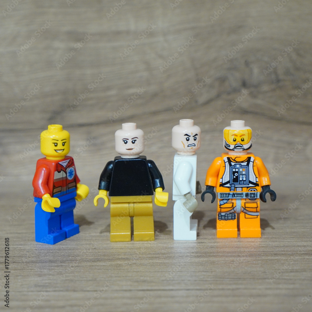 Naklejka premium Four Lego minifigures standing on a wooden surface, ready for adventure