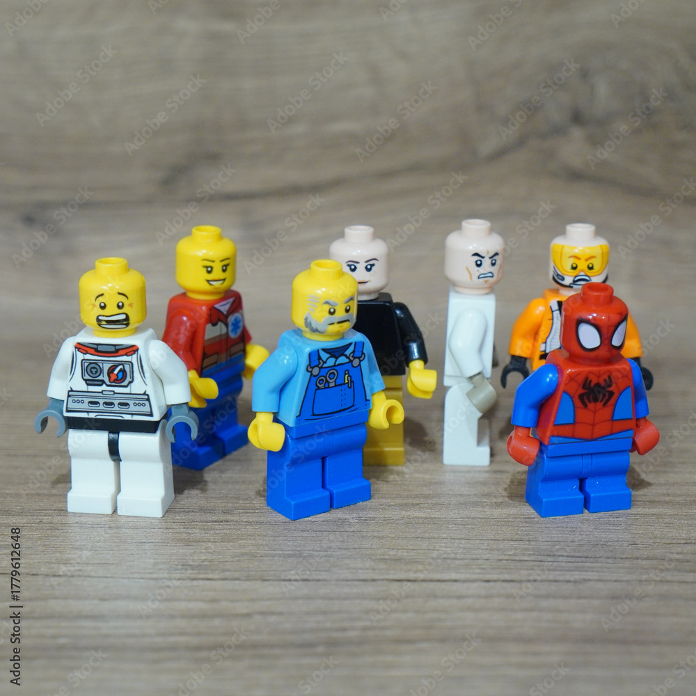 Naklejka premium Collection of Lego minifigures standing together on a wooden surface