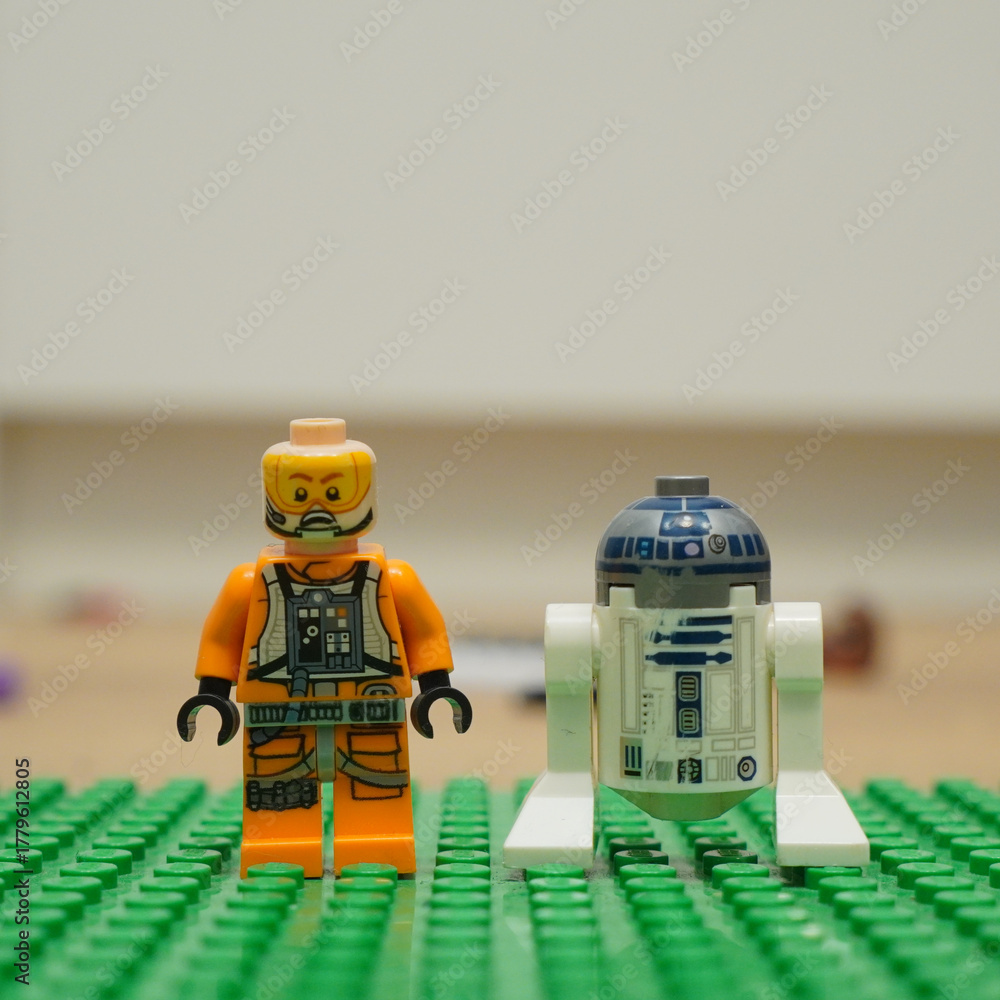 Naklejka premium Lego Star Wars figures of Luke Skywalker and R2-D2 standing together on a green baseplate