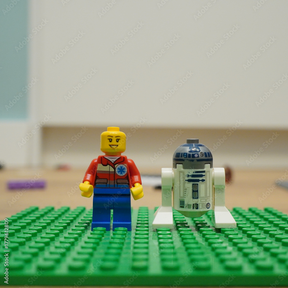 Fototapeta premium Lego minifigure and R2-D2 droid standing on a green baseplate