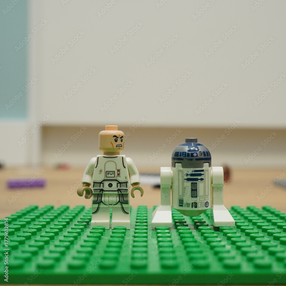 Naklejka premium Lego Star Wars figures of a rebel pilot and R2-D2 on a green baseplate