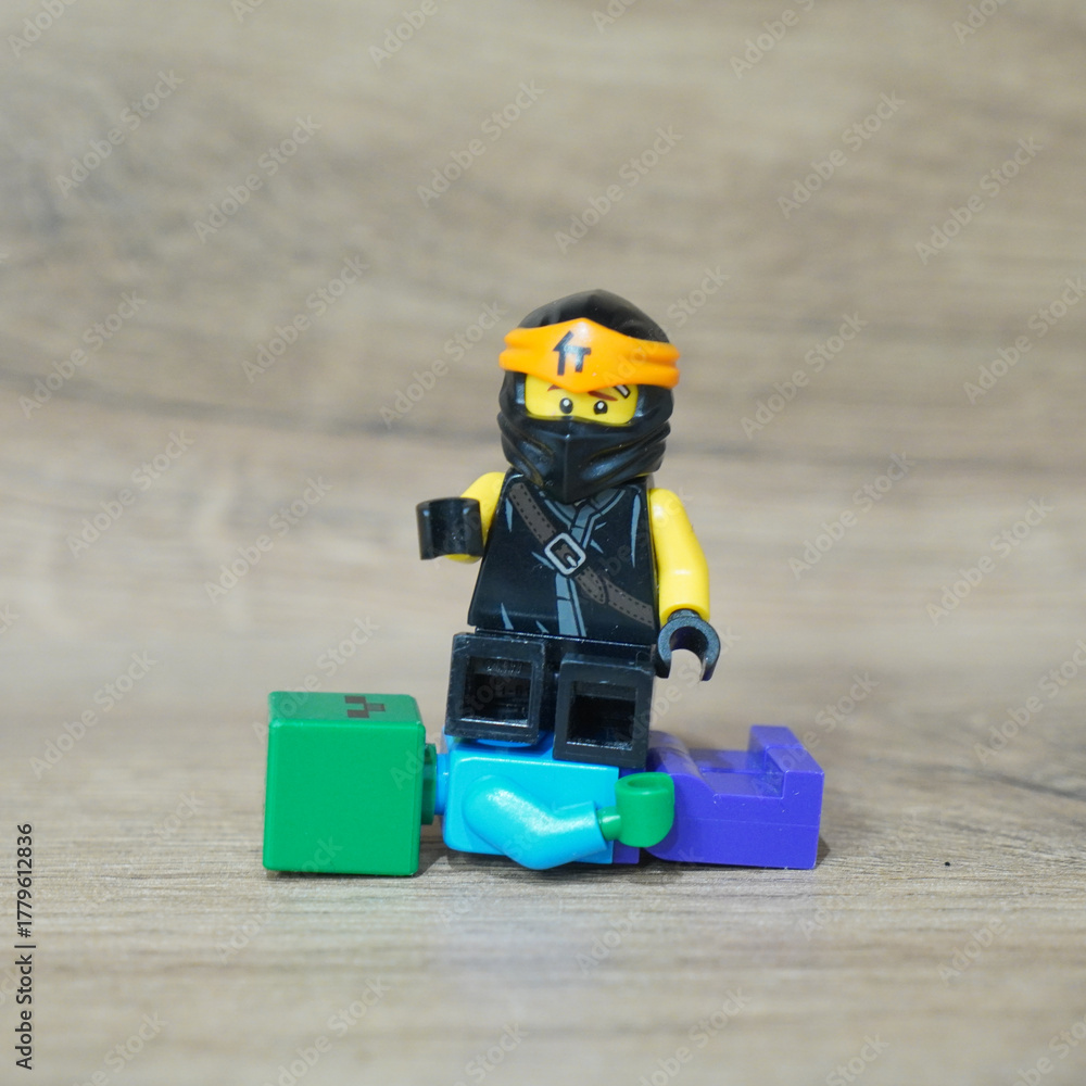 Fototapeta premium Lego Ninjago minifigure with Minecraft and Lego blocks on a wooden surface