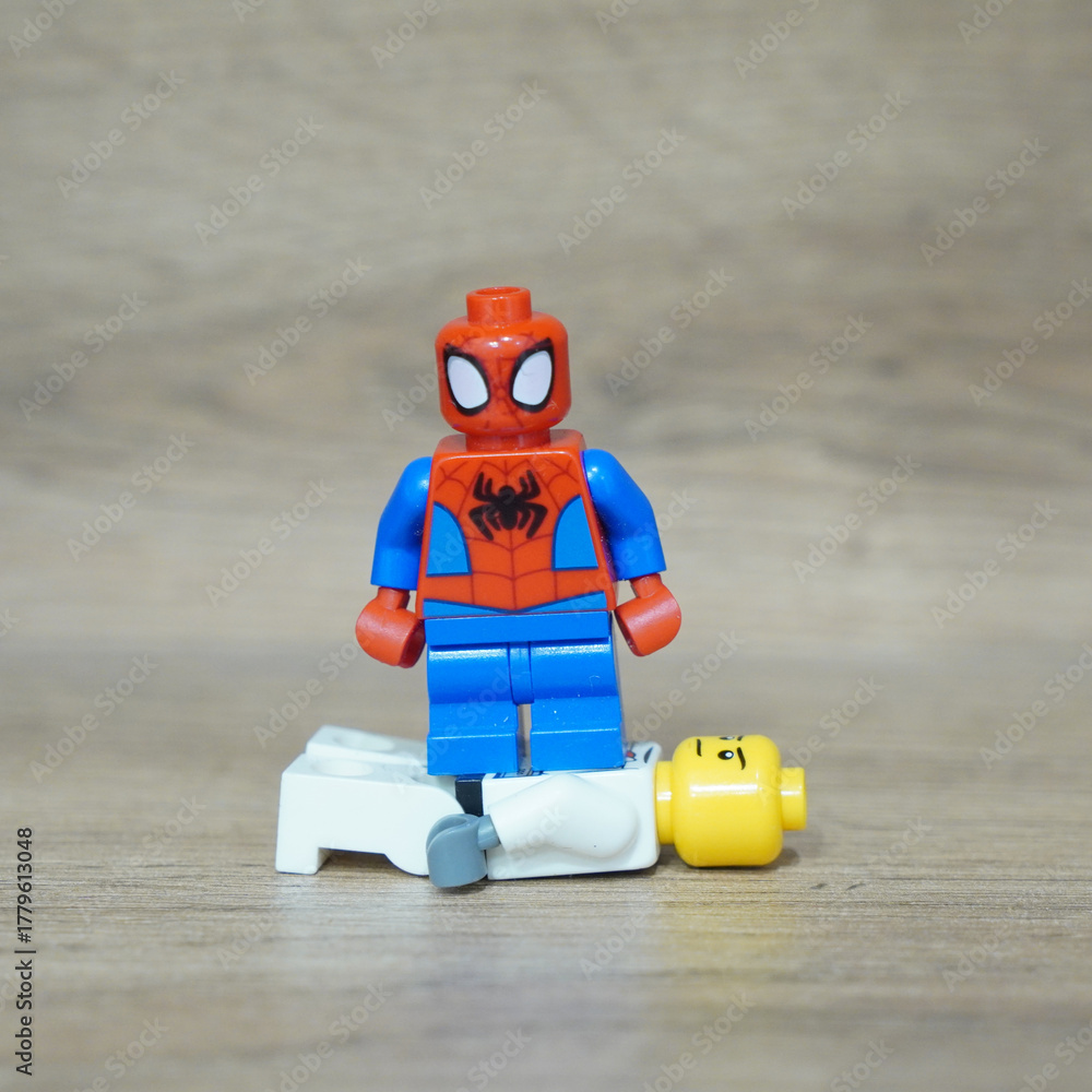 Naklejka premium Lego Spider-Man figure standing over another Lego figure on a wooden surface