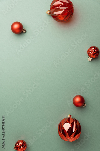 Red Christmas Ornaments on Green Background in Festive Flat Lay