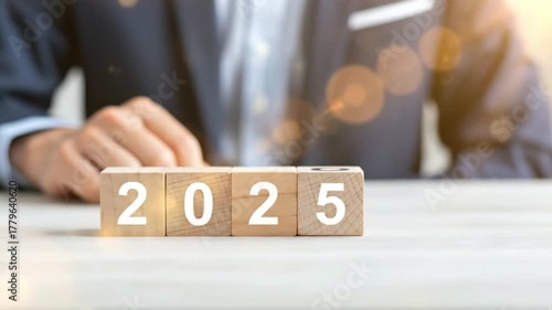 Looking Ahead to 2025: A glimpse of the future unfolds, symbolized by wooden blocks spelling out the year 2025, held by a person in a professional environment, represents foresight, planning.