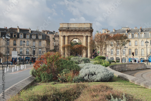 Flower bed in fall in front of triumphal arch. Bordeaux, France