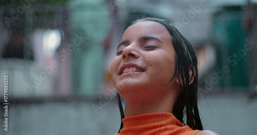Schilderij op canvas Little girl smiling with eyes closed, enjoying refreshing water spray outdoors i