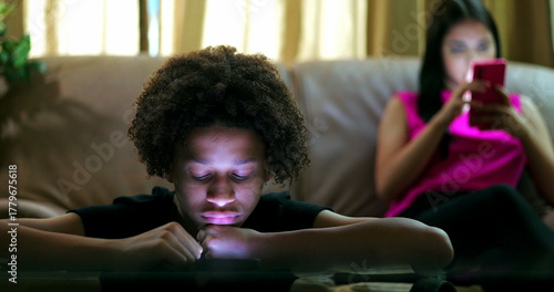 Konstfotografi Young boy staring at glowing smartphone screen, immersed in digital content, exp