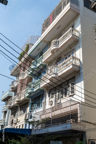 Old apartment building with balconies and cables in urban area under daylight, representing city lifestyle and local architecture concept
