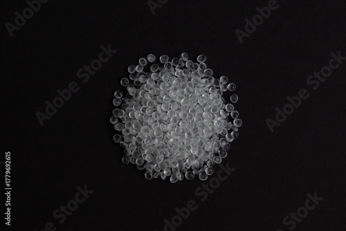Virgin Polystyrene granules on dark background, top view. General Purpose Polystyrene (GPPS) or Crystal PS. Granulated plastic polymer