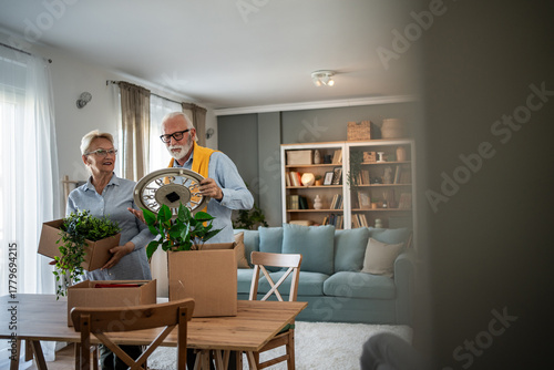 Foto Senior couple unpacking moving boxes in new home