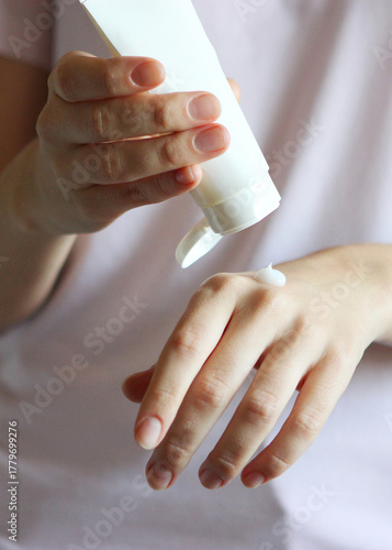 Wallpaper Mural girl smears her hands cosmetic cream. skin care,. Vertical photo format Torontodigital.ca