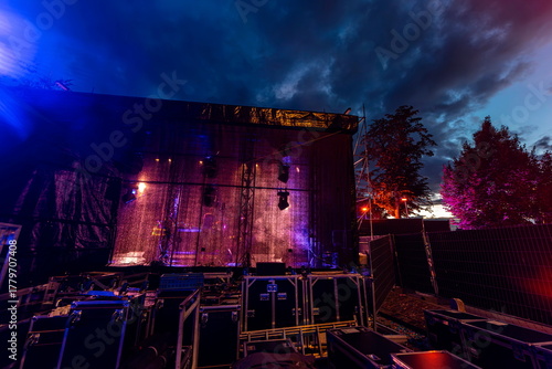 Fotografie Large outdoor stage with illuminated backdrop curtains and rigging against drama