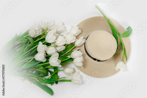 white tulips on the table with a hat. retro 