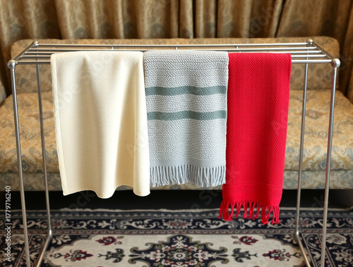Three Foldable Blankets Hung on a Metal Rack textile
