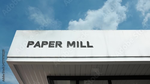 A paper mill word sign displayed on a large industrial manufacturing facility under a clear blue sky, symbolizing pulp production, forestry, resource industry, and manufacturing