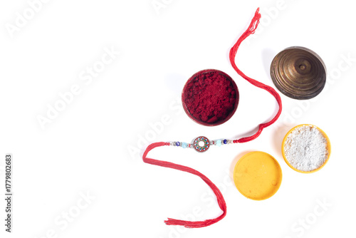 Rakhi bracelet with red thread, beads and colored powders for Raksha Bandhan celebration.