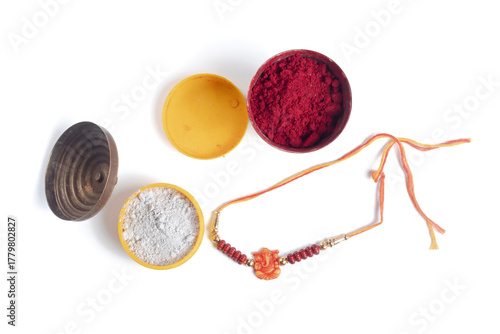 Colorful puja powders in small bowls with rakhi bangles for Raksha Bandhan celebration.