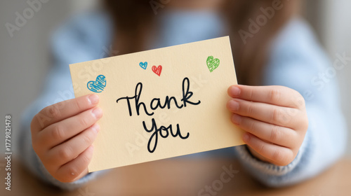 Heartwarming moment of child presenting a homemade thank you card to teacher