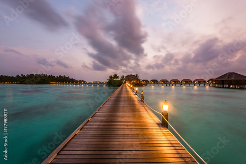 Fototapeta Naklejka Na Ścianę i Meble -  Tranquil closeup calm sea water waves with palm trees. Beautiful blue hours with bungalows. Tropical island beach landscape exotic shore coast. Summer vacation, holiday amazing nature, Maldives.
