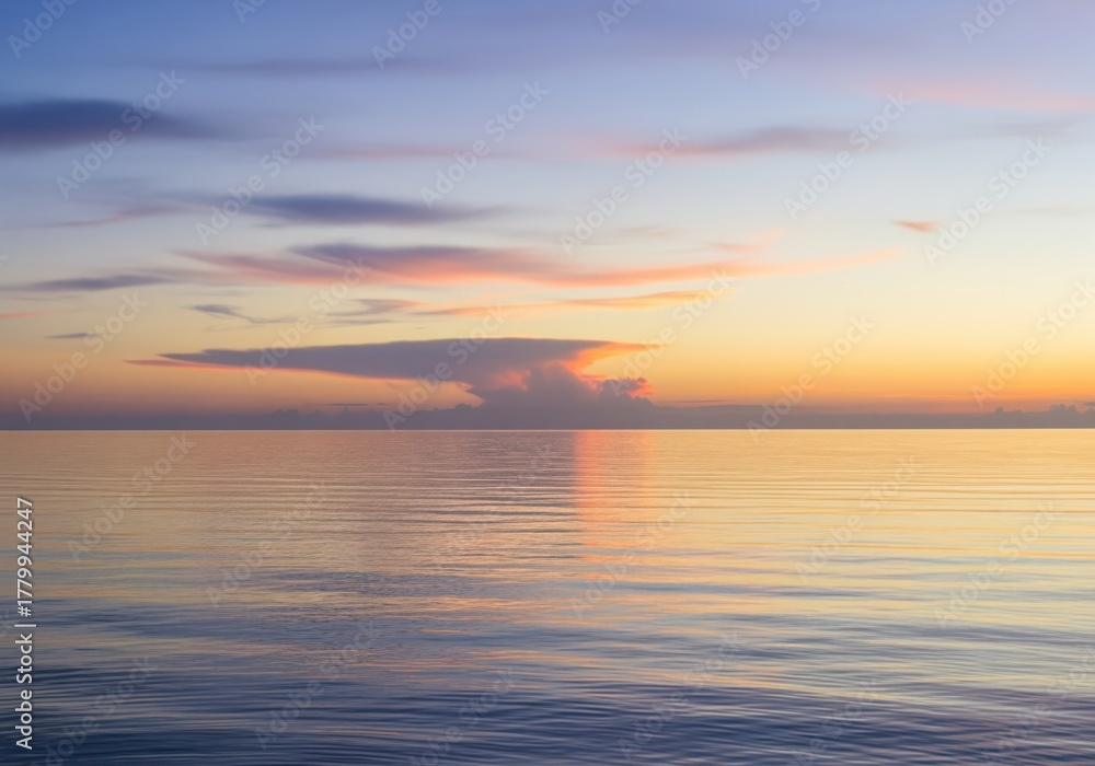 Obraz premium Breathtaking tranquil dawn over a calm sea with soft wispy pastel clouds
