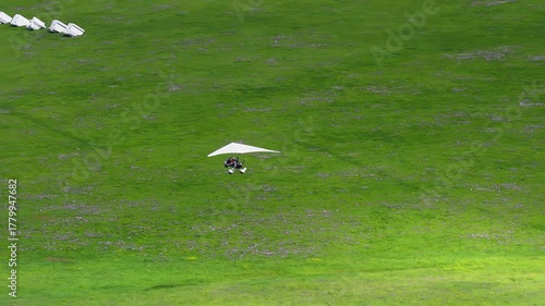 A powered hang glider flying over the grasslands