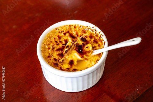 Fotografie Classic Creme Brulee in a Ramekin with a Spoon
