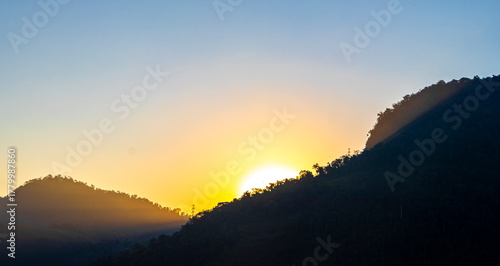 Golden colorful sunrise behind the tropical mountain mountains in Brazil.