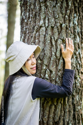 Canvas Print Asian woman hug pine trees