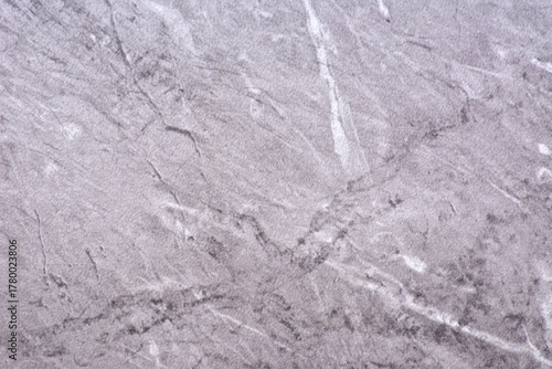 Light gray granite, polished natural stone surface with white and black veins, close-up.