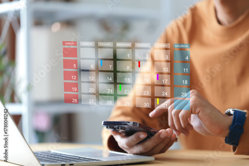 Businessman touching to smartphone with calendar and red circle mark for booking reminder appointment meeting and planing schedule concept.time management concept.