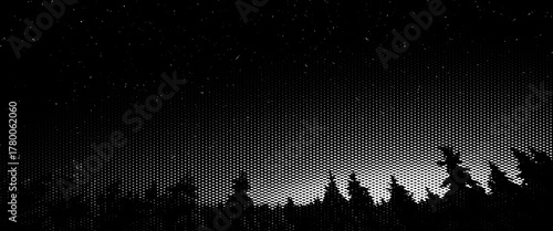 Silhouetted trees at night against a sky full of stars and the moon, a dark landscape silhouette of a forest.