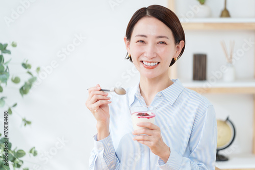 朝食にヨーグルトを食べる女性