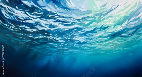 Underwater view of shimmering blue ocean surface with light rays filtering through the water