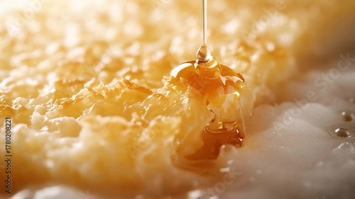 Golden Honey Flowing Over a Honeycomb in a Close-Up Shot.